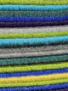 Close-up view of vibrant and fluffy stacked fabric layers in various colors, showcasing texture and pattern.